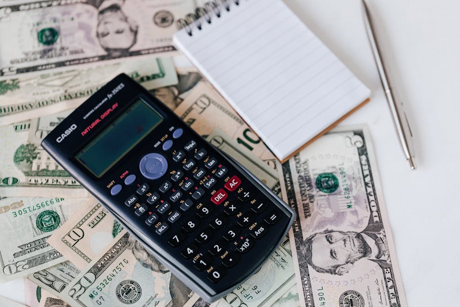 A calculator sitting on top of some money.