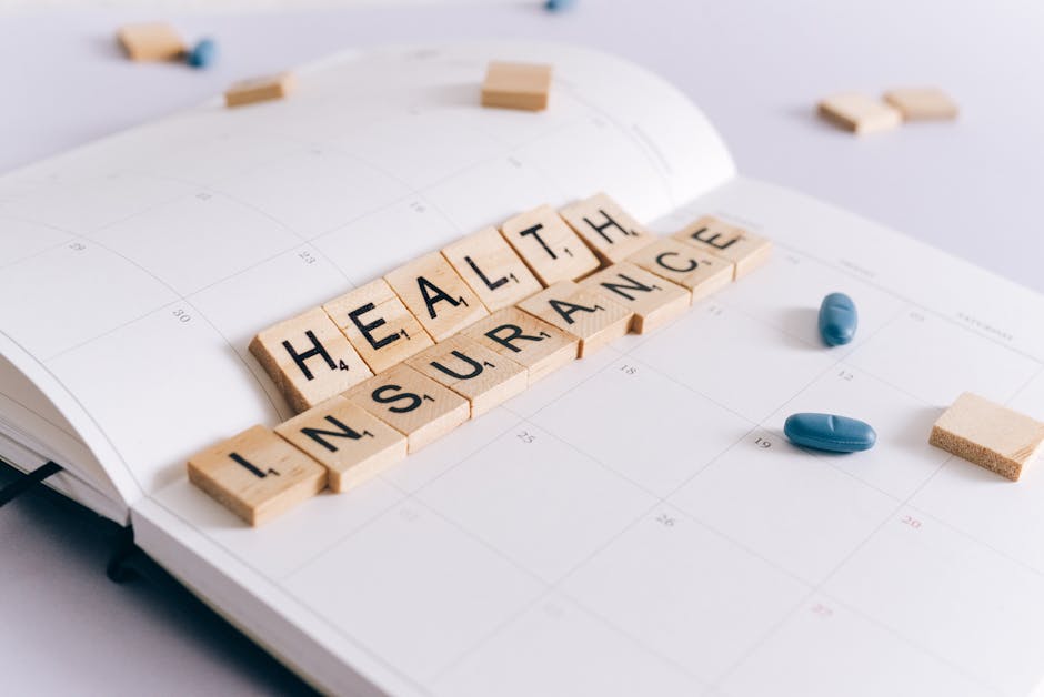 A table with the words health insurance spelled out in scrabble tiles.