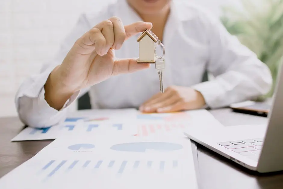 A person holding up a key to a house.